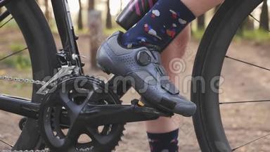 自行车鞋夹在踏板上。 自行车的概念。 链条和自行车轮关闭。 慢动作